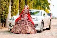 indian bride in a lehenga standing in front of a car